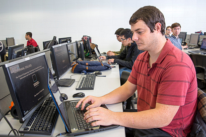 Male student in a computer lab working on his computer